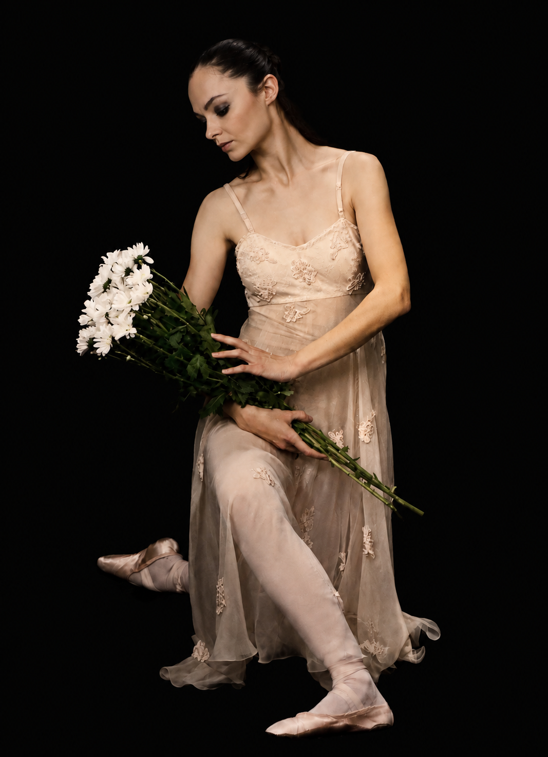 Ballerina in abito da danza con bouquet di fiori bianchi — posa seduta